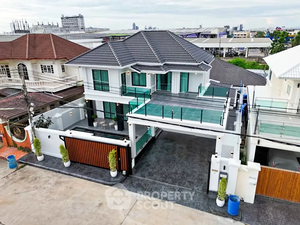 Stunning modern two-story house with spacious driveway and glass balcony, perfect for luxurious living.