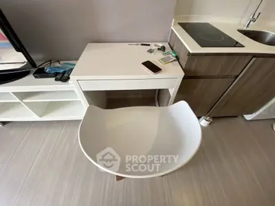 Modern compact kitchen with sleek cabinetry and integrated appliances in a stylish apartment.