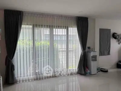 Spacious living room with large windows and elegant curtains, featuring a modern and minimalistic design.