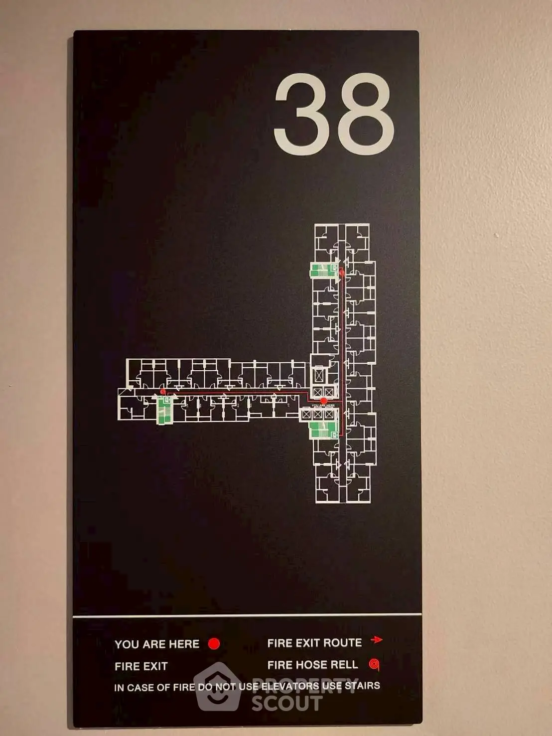 Floor plan map on wall indicating fire exits and routes on the 38th floor of a building.