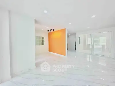 Spacious modern interior with marble flooring and vibrant accent wall