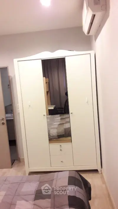 Cozy bedroom with modern wardrobe and air conditioning, perfect for comfortable living.