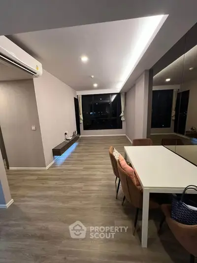 Modern living room with sleek design and large windows offering city views.