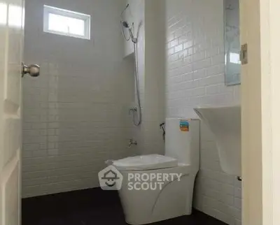Modern bathroom with sleek white tiles and contemporary fixtures.