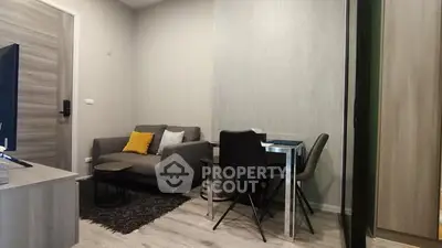 Cozy modern living room with stylish furniture and dining area in a compact space.