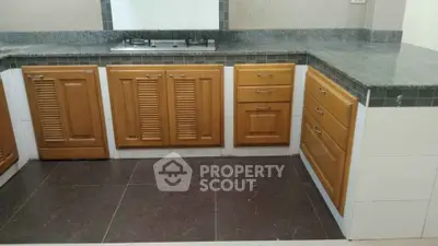 Spacious kitchen with wooden cabinets and sleek granite countertops