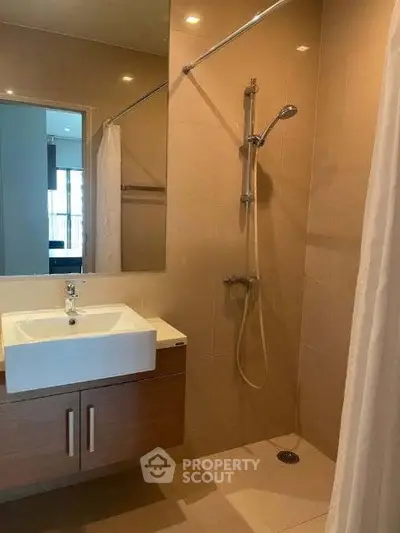 Modern bathroom with sleek shower and stylish vanity in contemporary apartment.