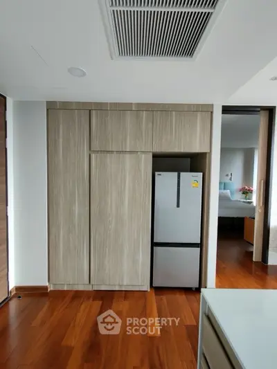 Modern kitchen with sleek wooden cabinetry and stainless steel fridge
