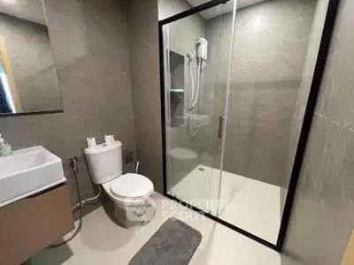 Modern bathroom with glass shower enclosure and sleek fixtures