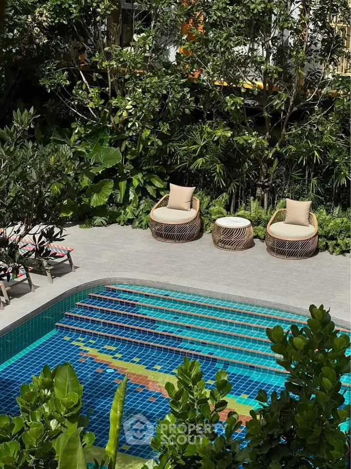 Luxurious outdoor pool area with stylish seating and lush greenery
