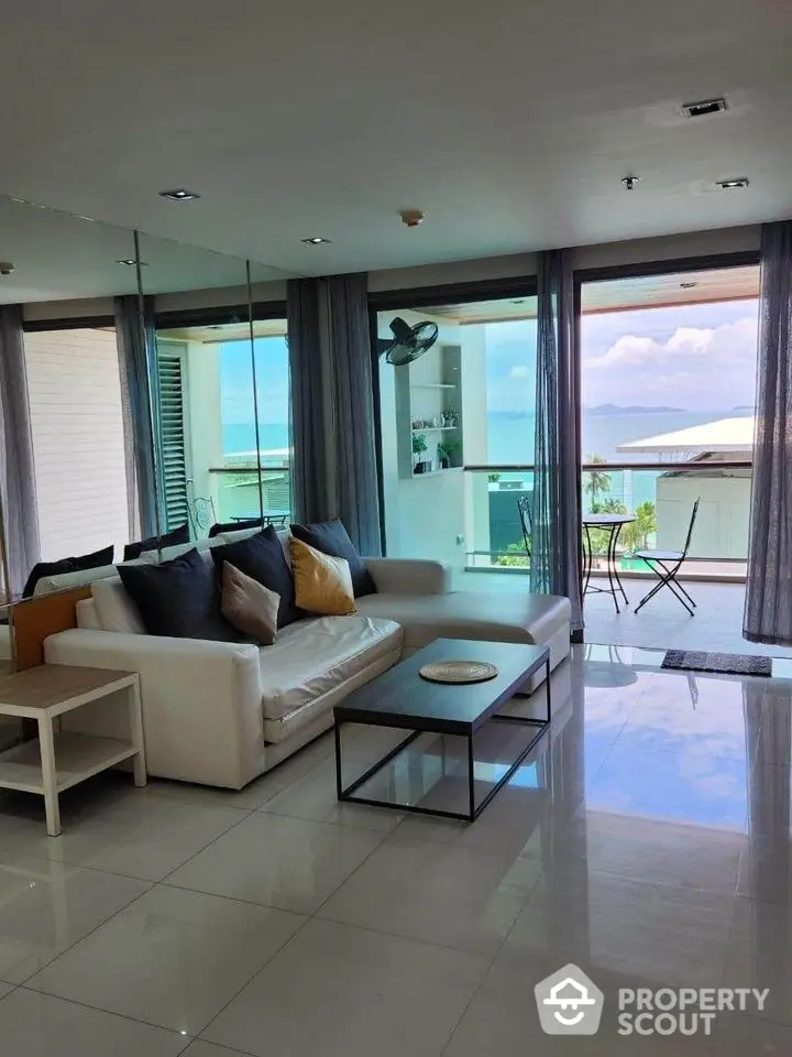 Luxurious living room with panoramic ocean view and spacious balcony access.