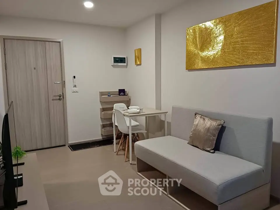 Modern living room with stylish decor and compact dining area in a cozy apartment.
