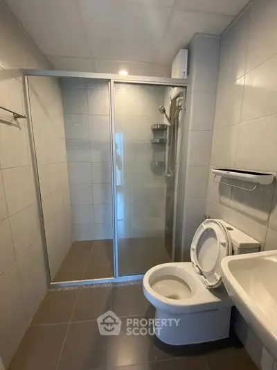 Modern bathroom with glass shower enclosure and sleek fixtures