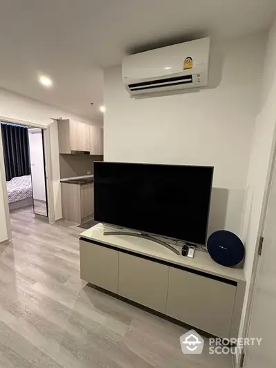 Modern living room with sleek TV setup and air conditioning in stylish apartment.