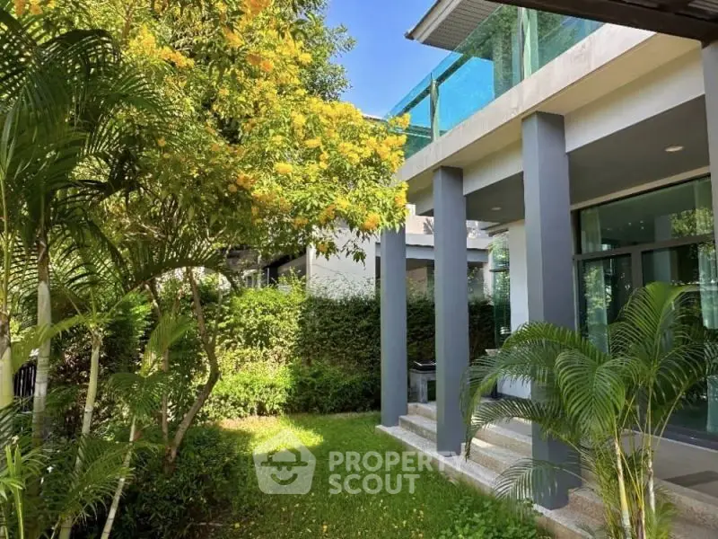 Modern home exterior with lush garden and sleek architectural design.