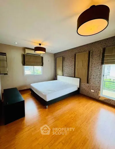 Spacious bedroom with modern lighting and wooden flooring