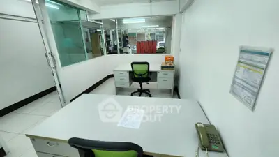 Spacious office space with modern furniture and glass partitions
