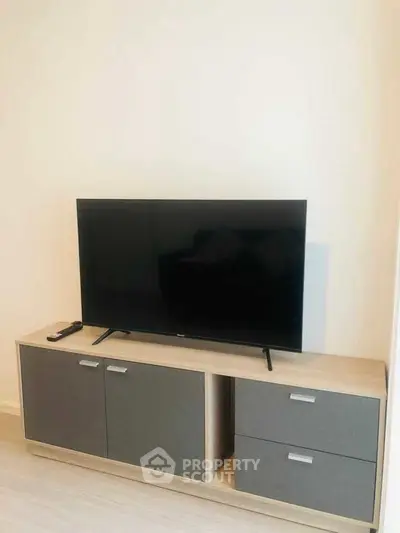 Modern living room with sleek TV stand and flat-screen TV, perfect for entertainment.
