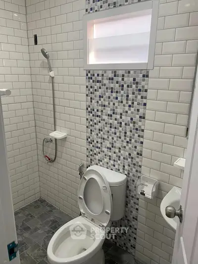 Modern bathroom with stylish tile design and functional shower setup.