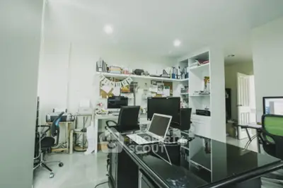 Modern home office with sleek black desk and multiple computer screens