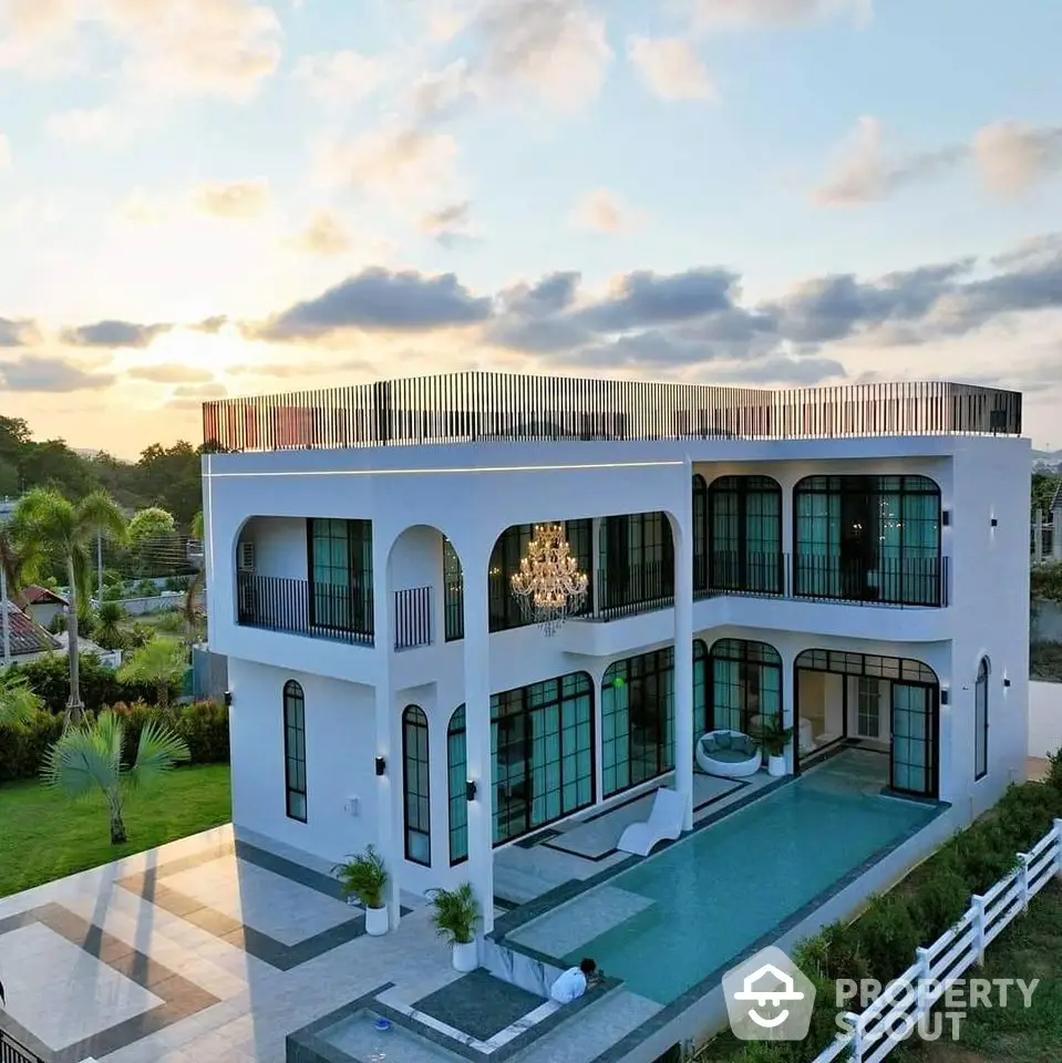 Luxurious modern villa with expansive pool and elegant architecture, featuring large windows and a spacious balcony.