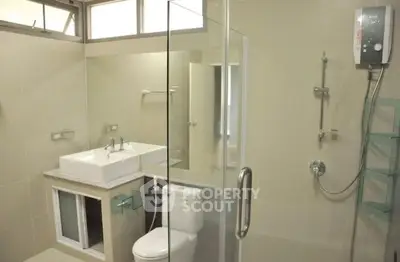 Modern bathroom with glass shower and sleek fixtures in a contemporary home.