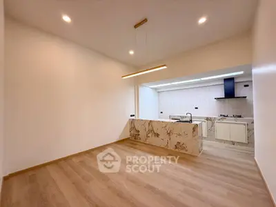 Modern open-layout kitchen with elegant marble island and wooden flooring