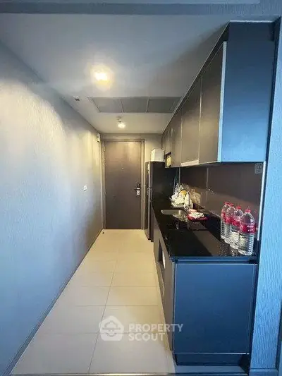 Modern kitchen with sleek cabinetry and black countertops in a contemporary apartment.