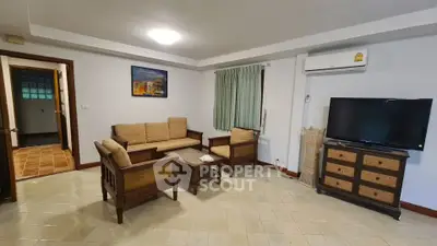 Spacious living room with cozy seating and modern amenities in a stylish apartment.