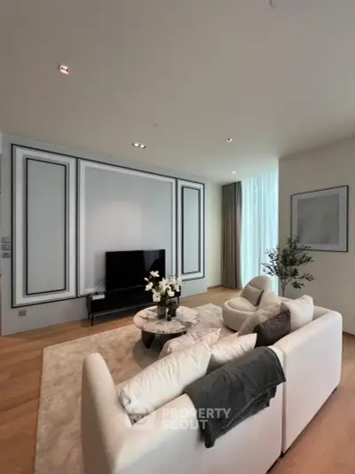 Elegant living room with modern decor, featuring a cozy sofa, stylish coffee table, and wall-mounted TV.
