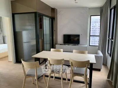 Modern open-plan living and dining area with natural light and stylish furnishings.