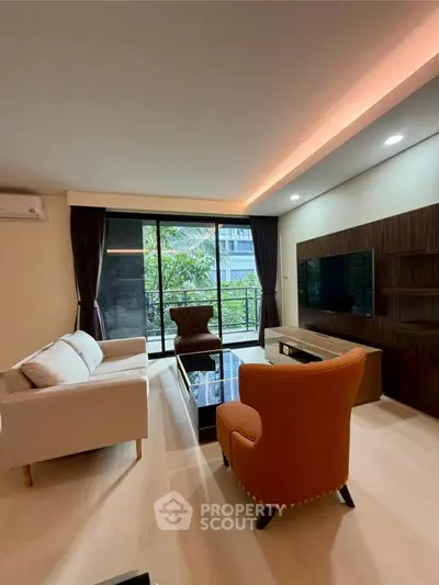 Spacious living room with modern furniture and large windows overlooking greenery.