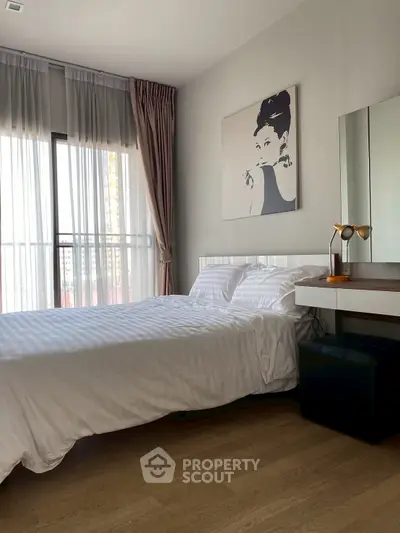 Stylish bedroom with modern decor and large window for natural light.