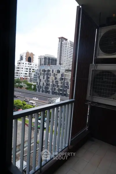 City view from a balcony with modern buildings and urban landscape.