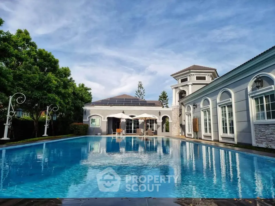 Luxurious villa with stunning pool and elegant architecture under a clear blue sky.