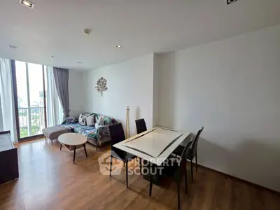Spacious living room with modern decor and large windows offering city views.