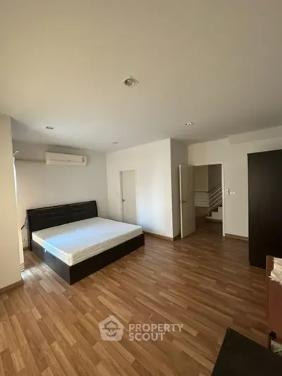 Spacious bedroom with wooden flooring and modern design
