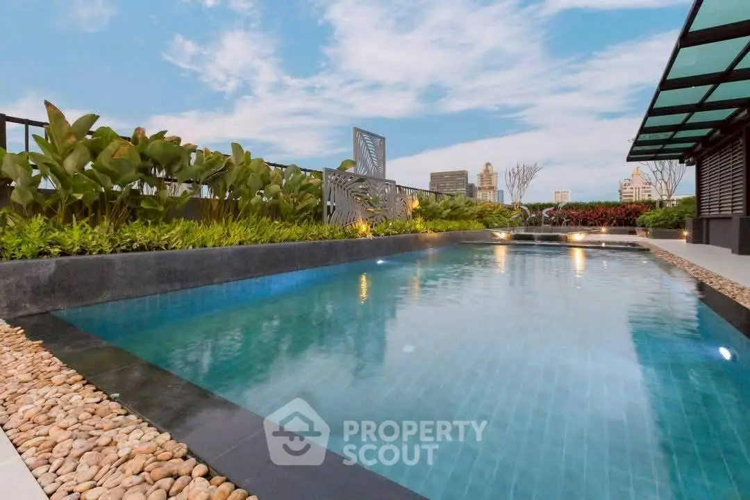 Luxurious rooftop pool with city skyline views and lush greenery.