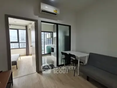Modern apartment interior with open layout, featuring a cozy living area and a glimpse of the bedroom.