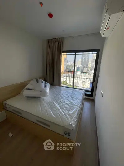 Modern bedroom with city view and balcony access in urban apartment