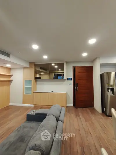 Modern living room with wooden flooring and sleek furniture in a contemporary apartment.
