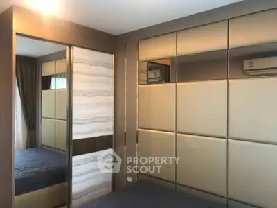 Modern bedroom with stylish paneling and mirrored wardrobe