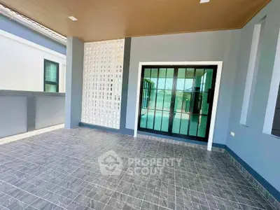 Spacious modern balcony with sleek tile flooring and large sliding glass doors.