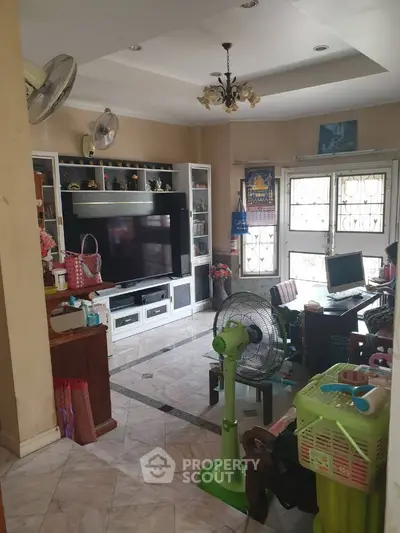 Cozy living room with TV, fans, and natural light