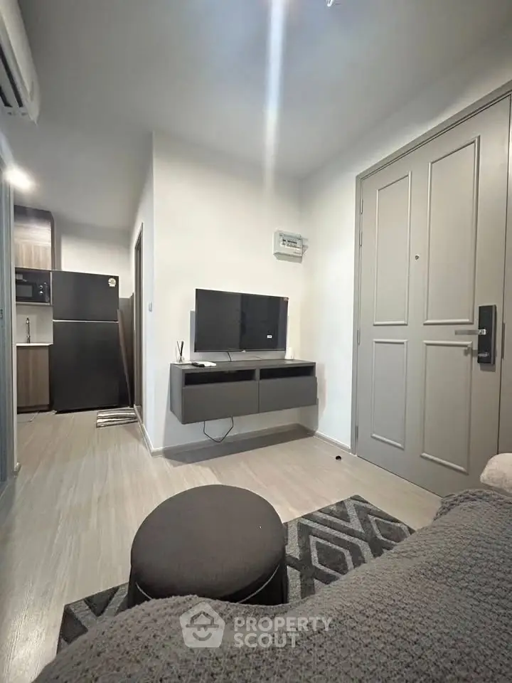 Modern living room with sleek furniture and open kitchen layout in a stylish apartment.