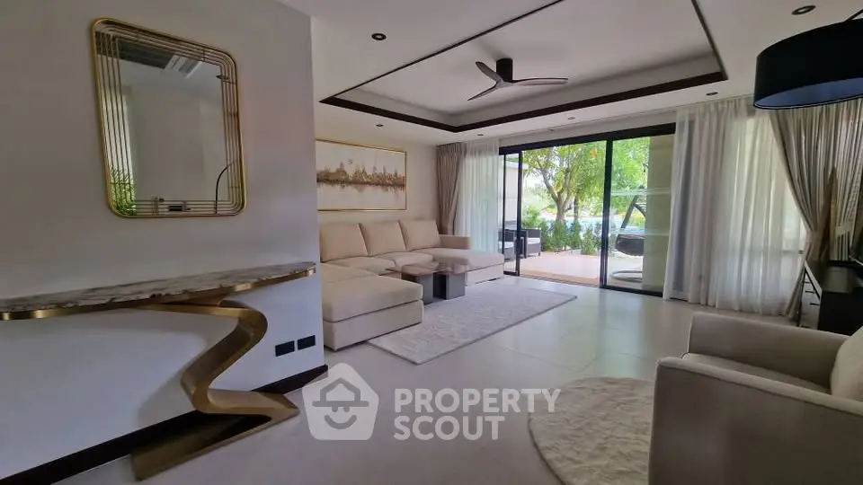 Luxurious living room with modern decor and large windows opening to a lush garden view.