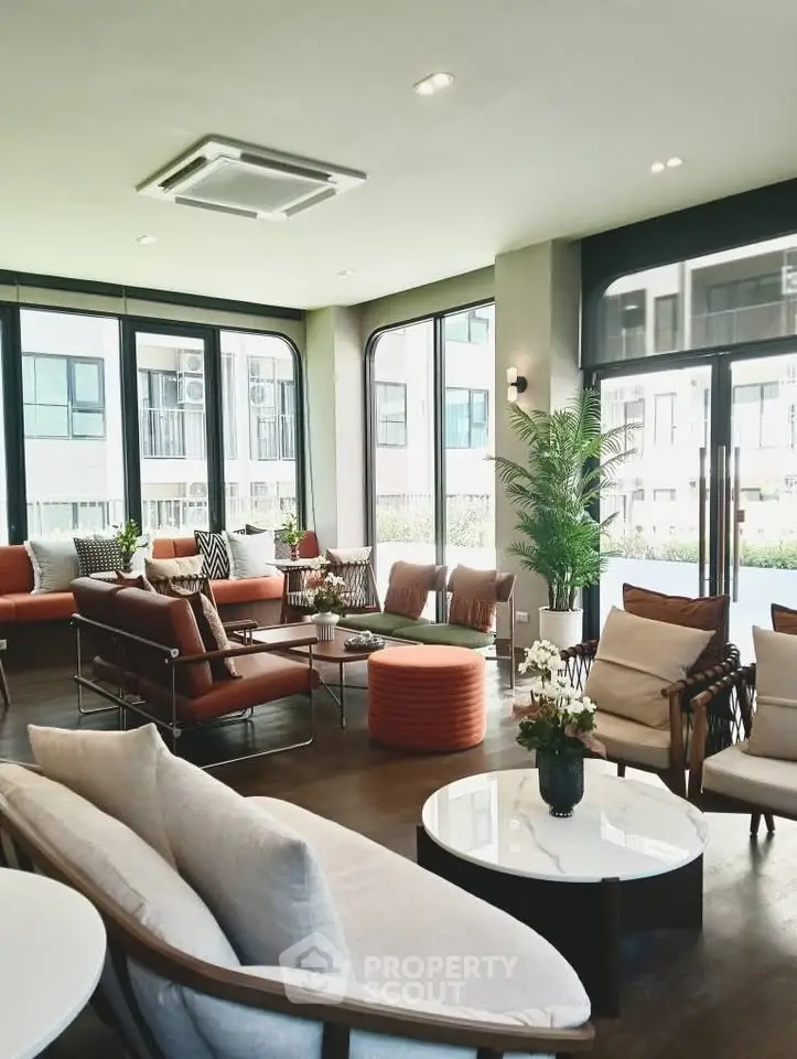 Spacious modern living room with elegant furniture and large windows offering natural light.
