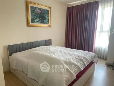 Cozy bedroom with elegant decor and natural light, featuring a stylish bed and framed artwork.