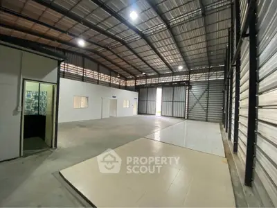 Spacious industrial warehouse with high ceilings and ample natural light.