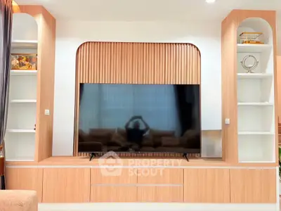 Modern living room with stylish TV unit and wooden shelving, perfect for contemporary home decor.